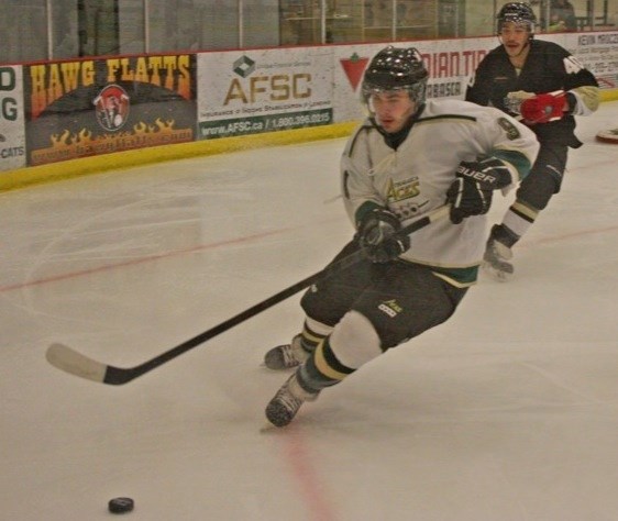 Chris Fraser of the Athabasca Aces follows the puck into the corner during game action