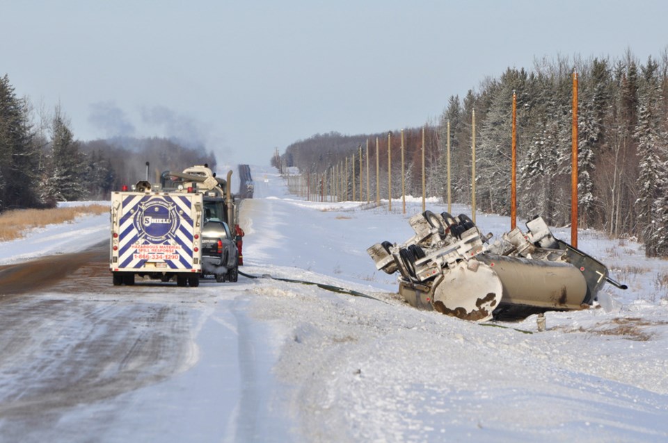 A fuel tanker lies in the east ditch of Highway 831 after the driver lost control in the early hours of Monday morning and flipped into the ditch.