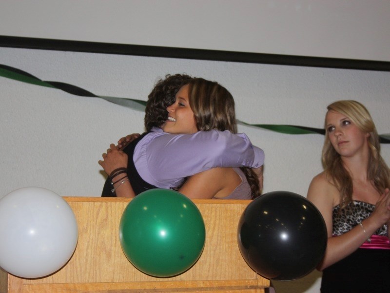 Maegan Kuzyk hugs senior girls&#8217; volleyball coach Joe Mireault as she accepts the MVP award.