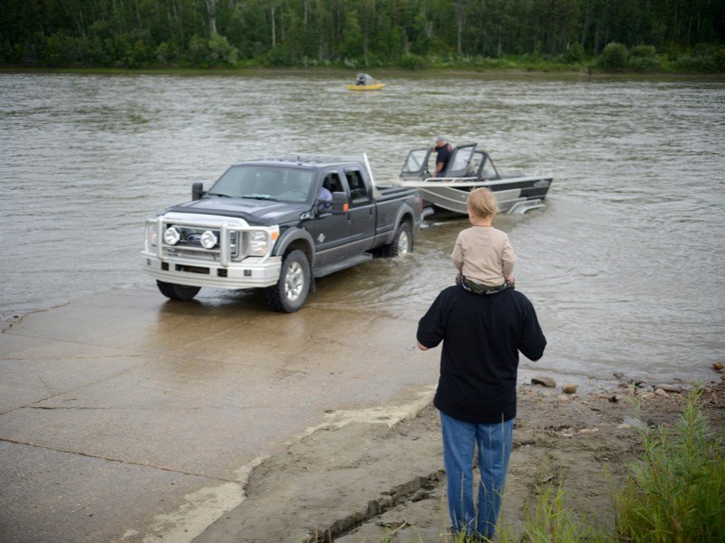 The fifth annual Jet Boat Poker Rally drew boats from around the region and as far as Saskatchewan to the Athabasca River last Saturday. Chris Chamberlain holds his nephew