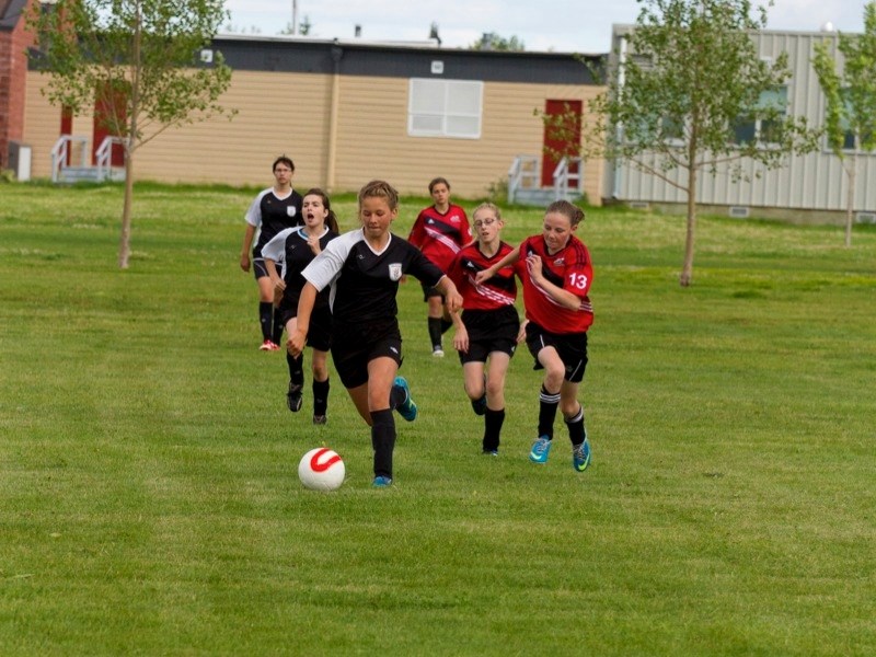 (players in black, l-r) Alisa Markowski, Alanie Devoe and Megan Boehlke of Athabasca U14 Blitz outrun SWU Union players from Calgary during provincials.