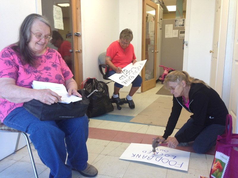 Boyle Food Bank volunteers put together placards after being locked out of the facility last Tuesday.