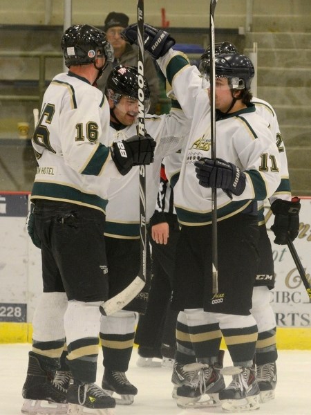 Shaun Kiselyk (left) and Sean Wrusch (right) congratulate Aces assistant captain Brent Hill (middle) on a goal against the Rocky Rams at last Sunday&#8217;s home game.