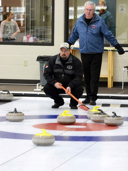 (l-r) Corey Jardine and Wayne Schinkinger curl at the Athabasca Regional Multiplex earlier this season.