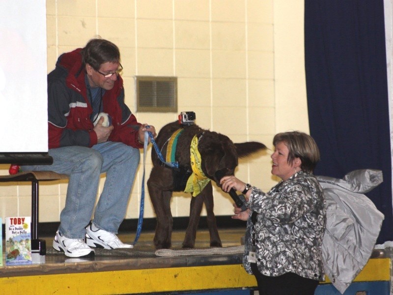 Chris Alcock and Charmaine Hammond with Toby Jr. at LTIS last Monday. Toby Jr. wears a Go-Pro camera on his back to capture footage for a &#8220;pawcumentary.”