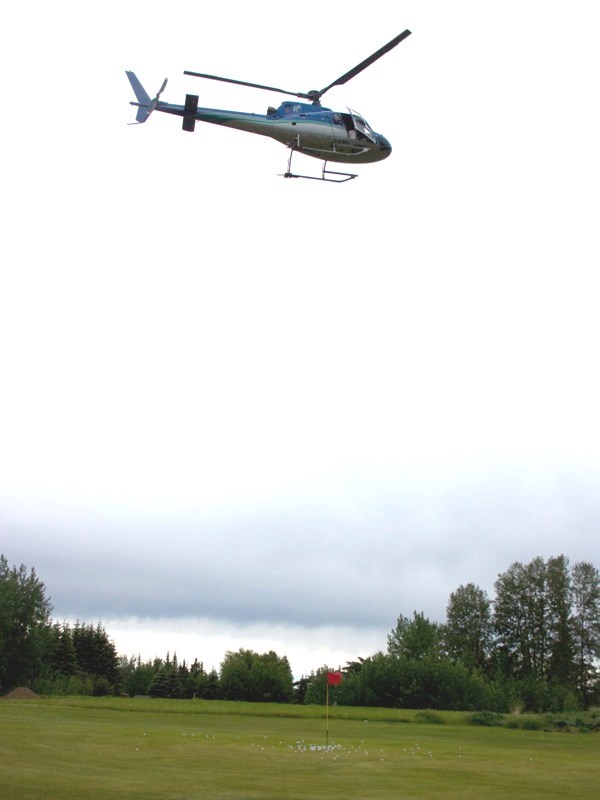 A helicopter hovers over the green at Skeleton Lake Golf Club following the ball drop at the 12th annual Bryan Mudryk Golf Classic on June 21. The balls were sold, numbered