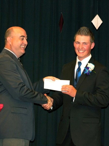 Boyle School vice-principal Larry Irla shakes hands with Colton Nikipelo as Nikipelo receives one of several awards during the school&#8217;s 2014 graduation ceremony last