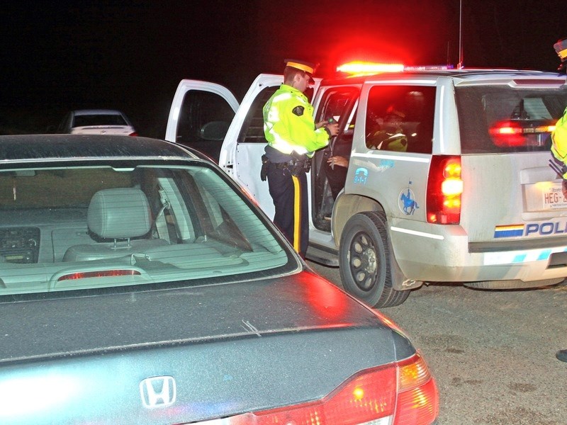 Boyle RCMP Cst. Alex Ayres conducts a roadside alcohol screening test on a driver at a CheckStop Friday night on Highway 63 just north of Atmore. RCMP and the Alberta