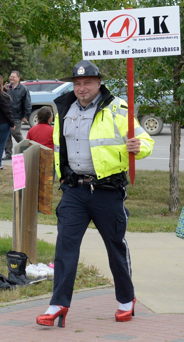 Town of Athabasca peace officer Shaun Woloschuk struts his stuff in his Wizard of Oz red pumps during the Walk a Mile fundraising event last Friday at the riverfront.