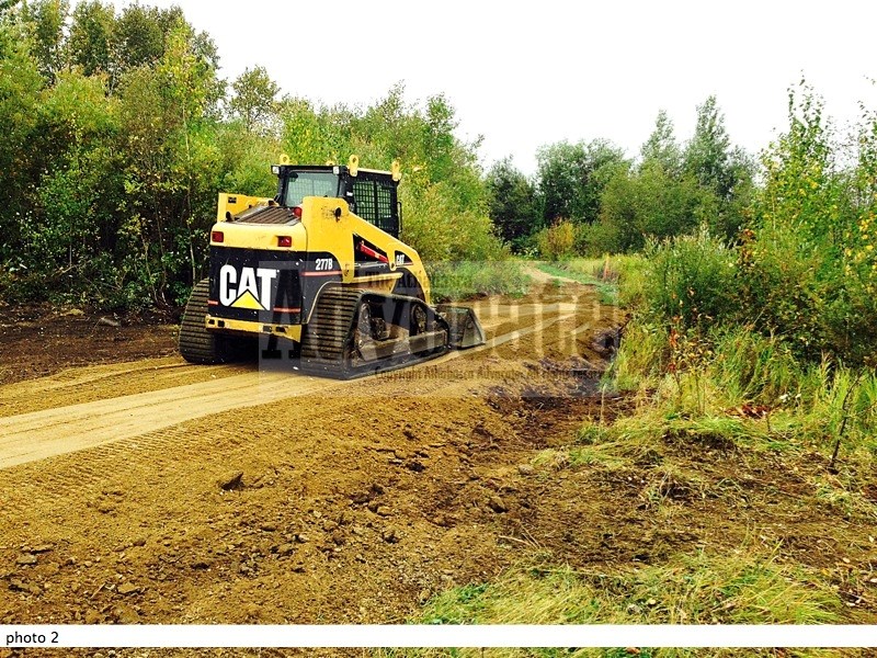 Lawrence Raaflaub uses a bobcat to do some finishing touches on one of the three culverts that have been installed on the trails.
