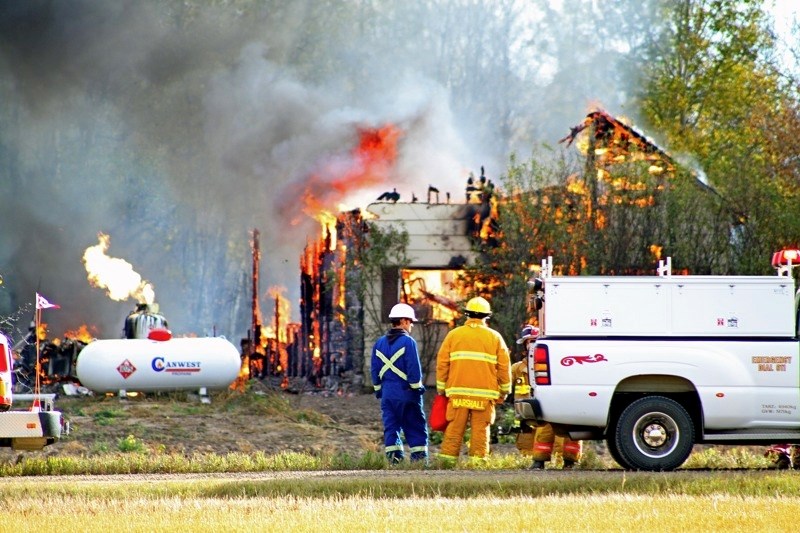 Emergency crews assess the situation after arriving at the home already partial destroyed by flames Wednesday. Investigators later found human remains in the debris.