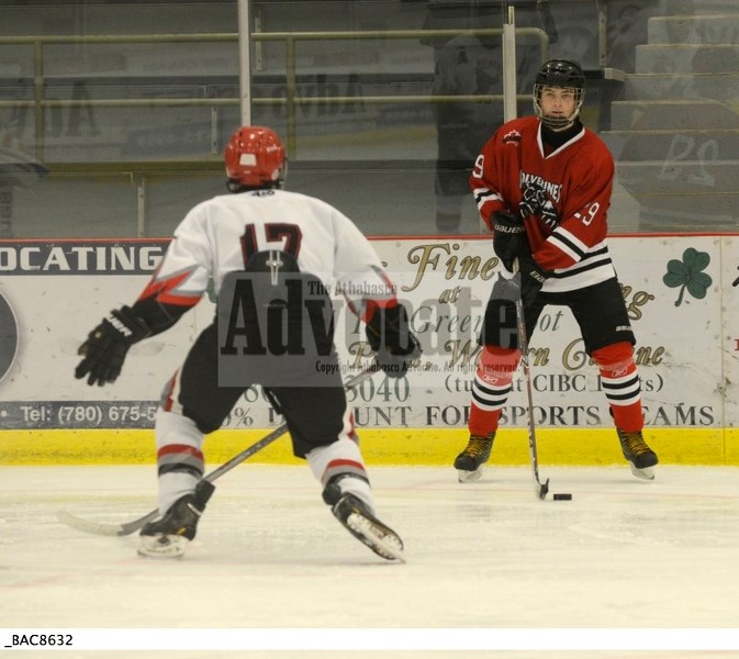 Bulls Jackson Roth goes at a Whitecourt Wolverines players near the boards during their game at the Multiplex on Sunday.