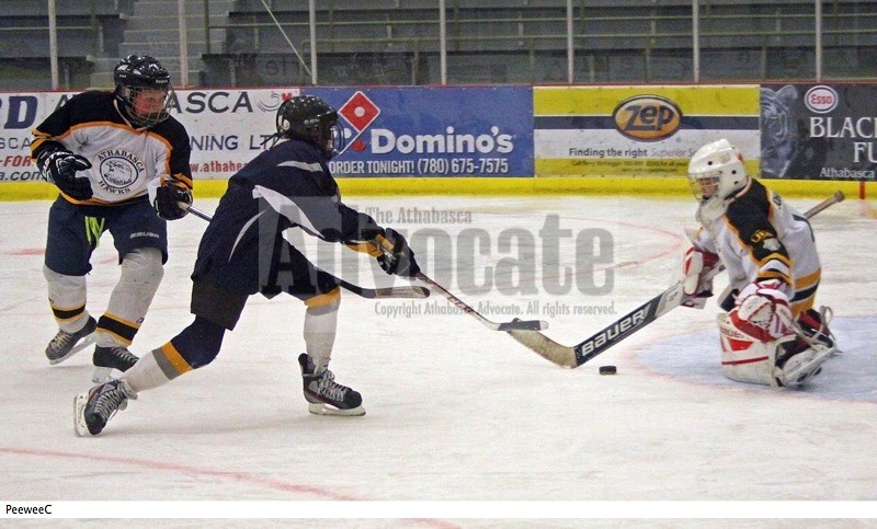 Athabasca PeeWee C Hawks goaltender Jakub Johnson gets the pads down to stop this shot on net as teammate Joshua Funk looks to keep the Edson player from reaching any rebound 