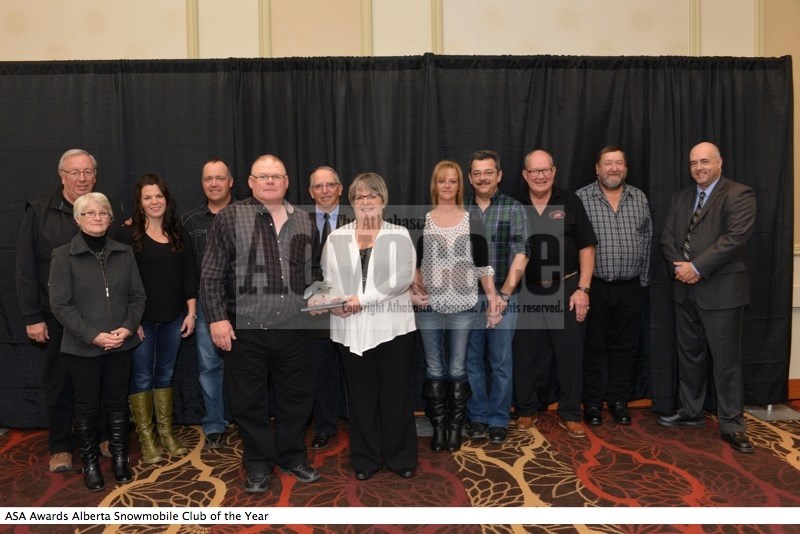 (front, l-r) Athabasca River Runners president Dave Bilsky and Jean Bilsky stand with the Alberta Snowmobile Association award as Club of the Year. Also pictured (back) are