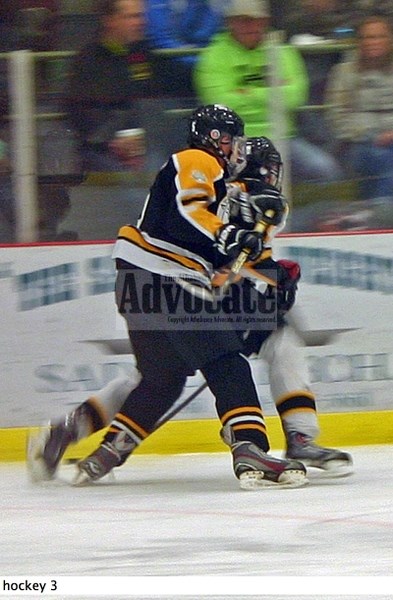 Evan Ladouceur (8 white) of Athbasca Bantam B WhiteHawks is taken off the puck and into the boards with a good check by Athabasca Bantam B BlackHawks Ryan Tomuschat (7) as