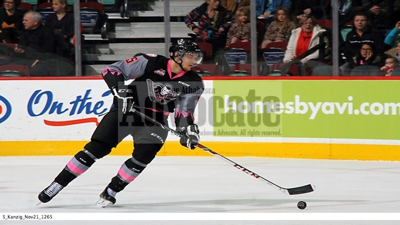 Keegan Kanzig lugs the puck out of his zone in his first game Friday night at the Saddledome with the Calgary Hitmen. Kanzig was traded late Wednesday night from Victoria.