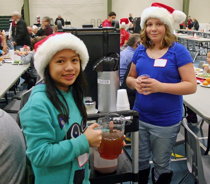 Wyeth Tan (l) and Kaitlin Labonte from the LTIS Leadership squad handing out drinks like coffee and iced tea to be enjoyed by those sitting down to their turkey dinner with