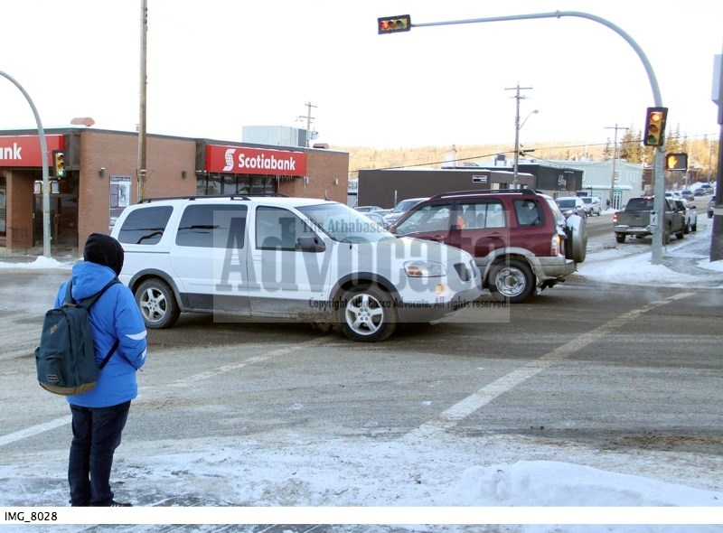 A pedestrian obeys a traffic signal and waits to cross the street in Athabasca last week while one vehicle waits to make a safe left turn, things that will keep RCMP happy