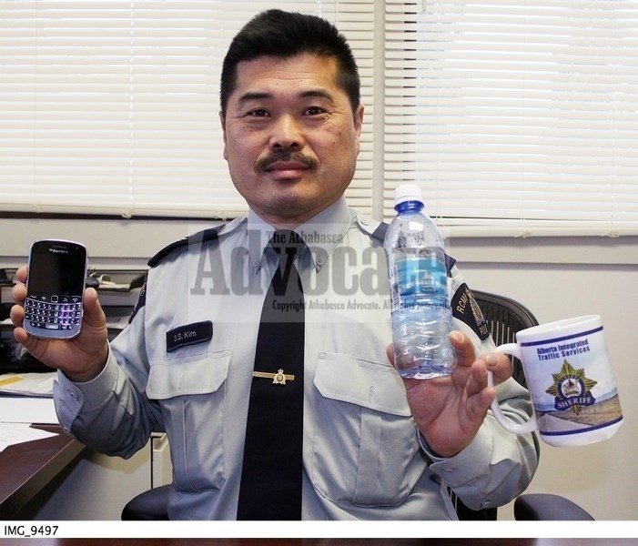 Sgt Sonny Kim, who is in charge of the Athabasca/Boyle Integrated Traffic Unit, demonstrates just a few of the items that could find drivers being handed a $172 distracted