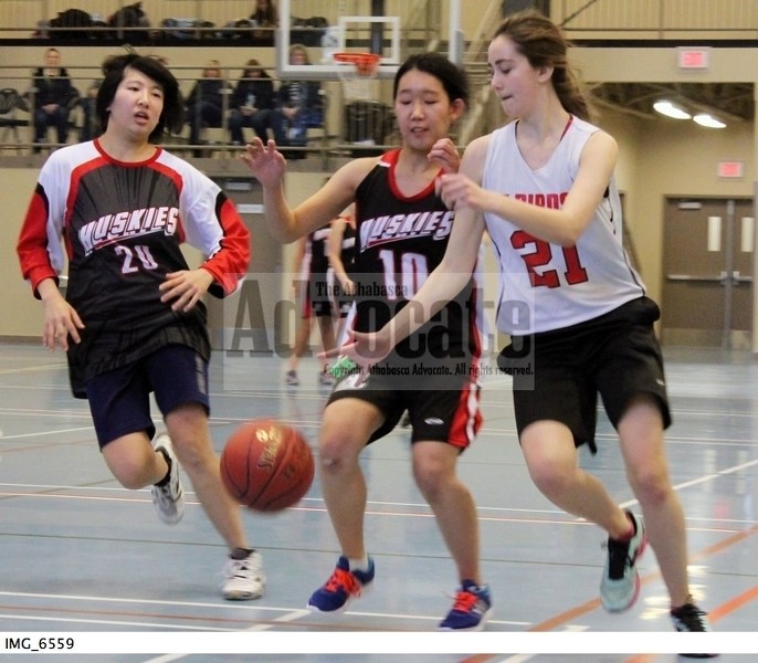 Huskies Miki Tainaka and Asahi Takahashi attempt to steal the ball from an RF Staples player during action on the weekend.