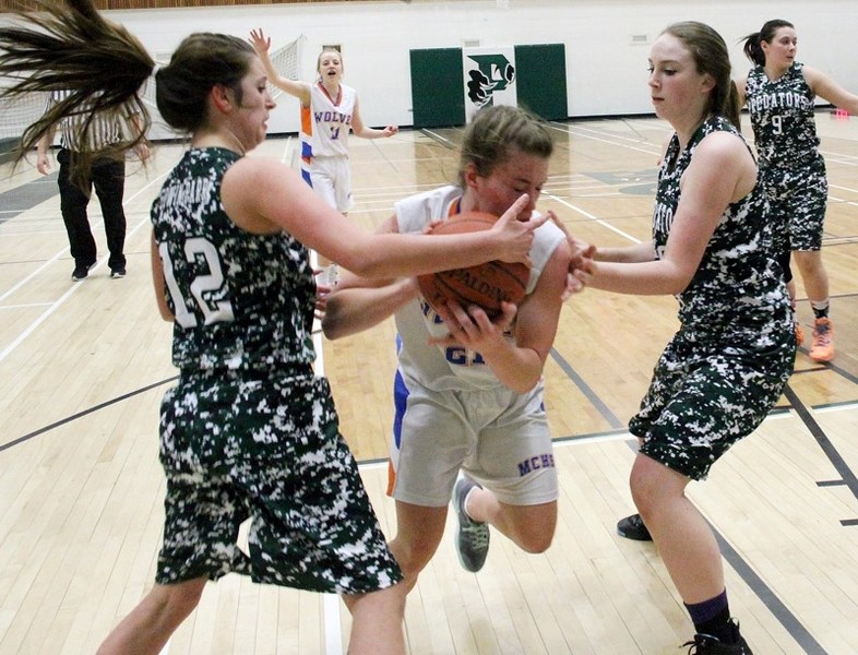 Predators Kelsie Martin (12) and Hailey Dunsire (8) battle for the ball with a Morinville player during first quarter action during the 3A zone final Saturday night at the