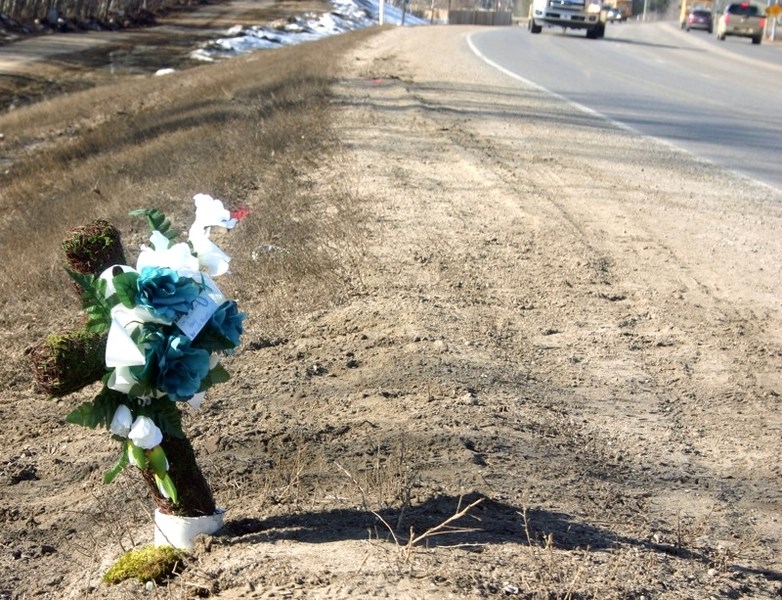 An impromtu roadside memorial appeared Wednesday at the spot of the collision on the Highway 55 east hill.