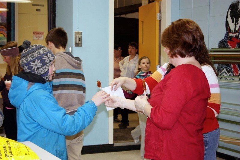 An LTIS student receives the tasty le tire – frozen maple-syrup-on-a-stick during French Cultural Day last Thursday.