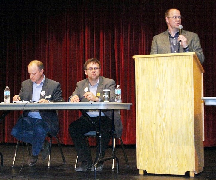 (l-r) Wildrose candidate Travis Olson and NDP candidate Colin Piquette sit on stage as AUFA president Lawton Shaw introduces the pair Monday night.