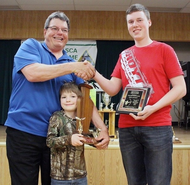 Brian Rudyk and Seth Knisley present Colton Gustafson (r) with the Big Game Open Archery award.