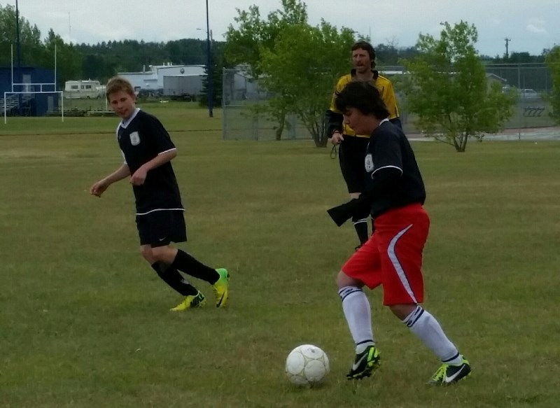 (l-r) Devin Head and Yamach Yilmaz of the Athabasca U14 Boys Titans FC pass the ball upfield during Tri-County Cup play in Ardrossan Saturday. The Titans won all three games