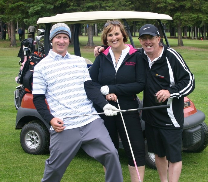 Tom Legassie, Charlene and Wally Luberda ham it up before teeing off.