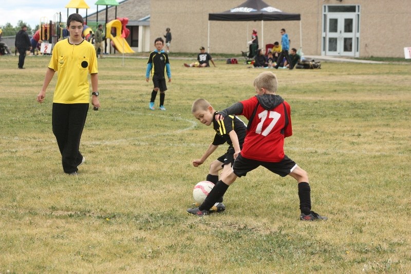 Athabasca U10 Strikers FC player Lochlan Hefferan (17) and Lac La Biche Dynamite Brody Finnestad spar for the ball.