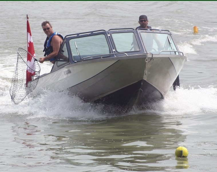 Darcy Webb and Jason Isaac move in to retrieve a floating soccer ball during the annual jet boat rally boat rodeo held on July 12.