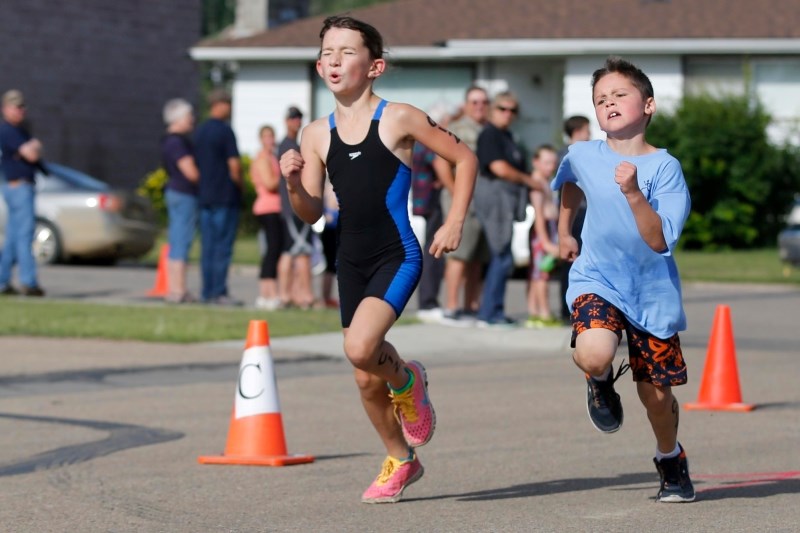 Julianne Safar, (left) races Mason Soderburg in the last stretch of the Kids of Steel ages 8 and 9 category.