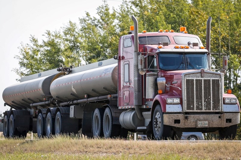 A transport truck drives into Athabasca on Highway 55 pulling two fuel tanks behind it.