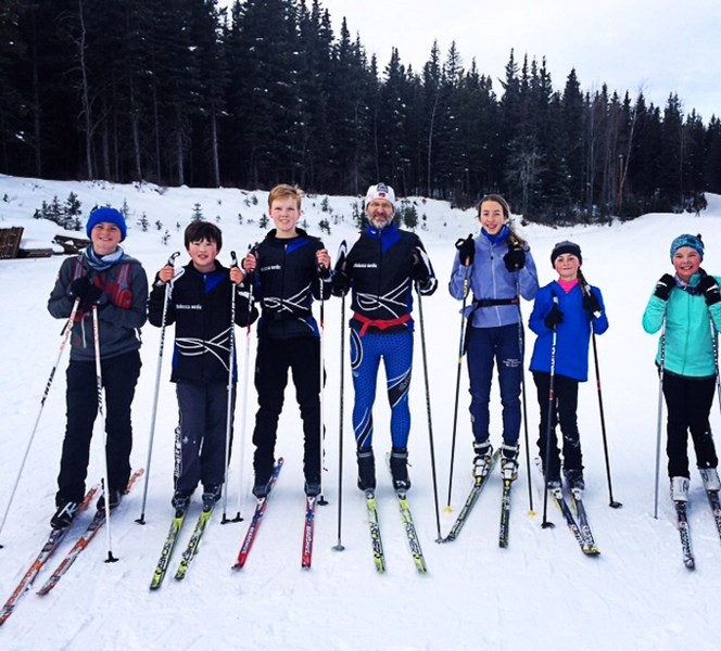 Athabasca Nordic Ski coach, Henrik Asfeltd stands with six of his competitive ski racers while at the Alberta Winter Games Qualifing loppet in Edmonton.