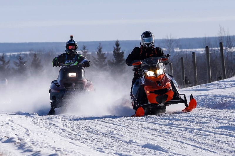 Dave McLean and Mike Sakaluk of Edmonton race down the trail after passing the first check point of the Athabasca River Runners annual snowmobile rally on Saturday.
