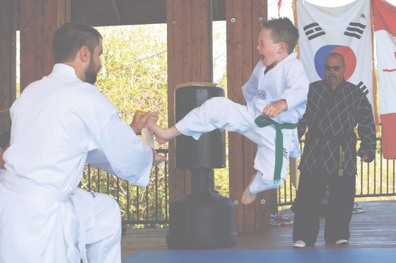 Jeremy Campbell performs a flying side kick to help him progress to a blue stripe belt at the Athabasca Riverfront Stage on June 18.