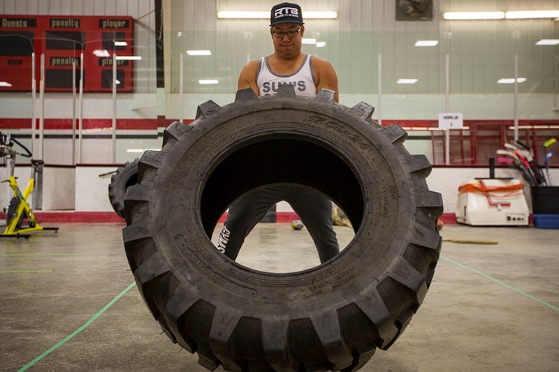 Sport mentor Brandon Kaga lifts a tire across the arena floor. The variety of sports and mentors helps develop kids co-ordination and keeps them entertained.