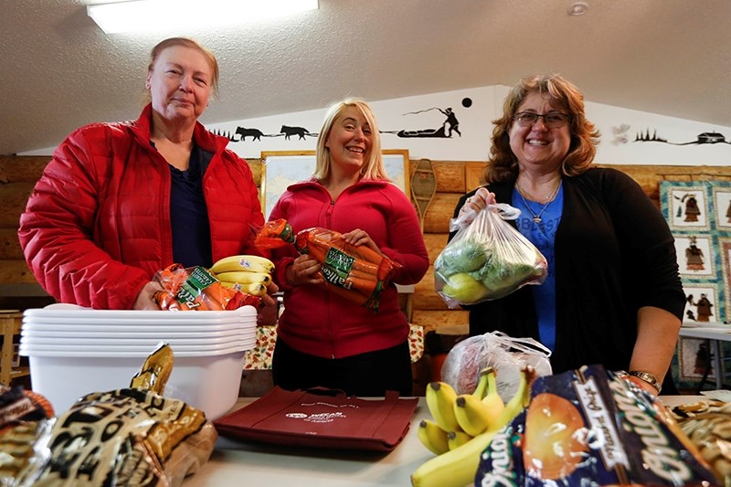 Karel Epp (left) and Ida Edwards (right) stand beside Renee Sibera while collecting food baskets at the Native Friendship Centre.