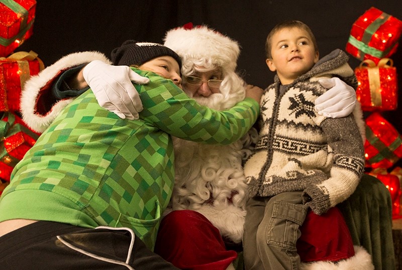 Shaylene Sauer gives Santa Claus a big hug while Xander Gladue sits on his knee. Sauer and Gladue were just two of the many kids that got their picture taken with Santa at