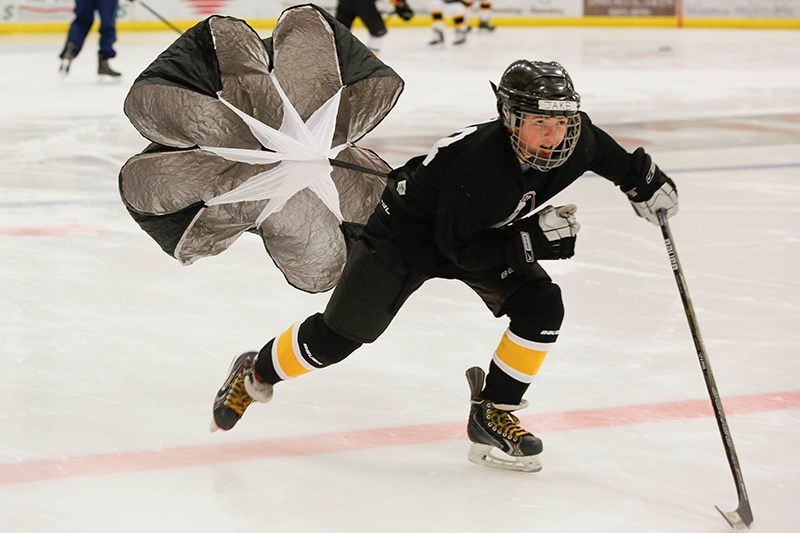 Jake Duncan skates down the ice with a parachute on his back to create more drag.