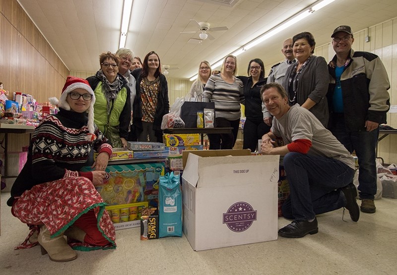 Volunteers with Boyle&#8217;s Santas Anonymous gather around food items donated for the sack challenge on Dec. 2.