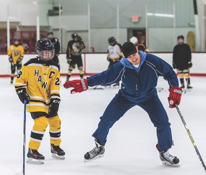 Rowan Ponich is instructed by Steven Goertzen on how to handle sharp turns with the puck at an Athabasca Minor Hockey spring training camp last weekend.