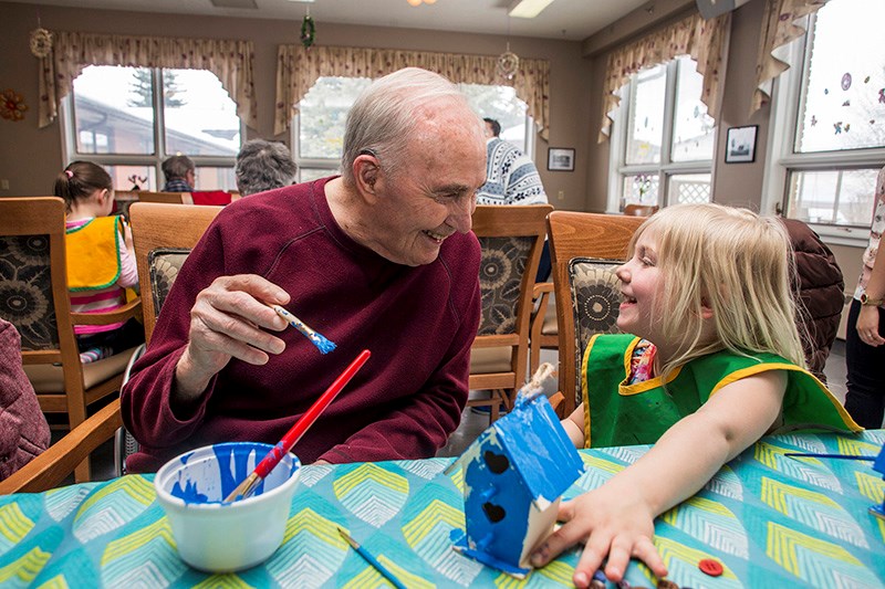 Athabasca Extendicare resident Hal Johnston paints a birdhouse with four-year-old Braidy Fuchs during Parent Link&#8217;s new &#8220;Partners In Time &#8221; program April