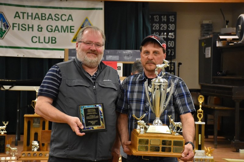 Doug Frost of the Long and Narrow Lakes Stewardship Society accepts the Conservation Trophy from Greg Woytovich.