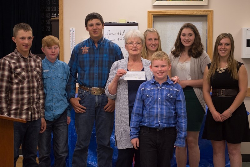 Athabasca 4-H Beef Club members gave the Athabasca and District Seniors Society a cheque for $1,100 after selling their woodworking project at auction to Brian and Louise