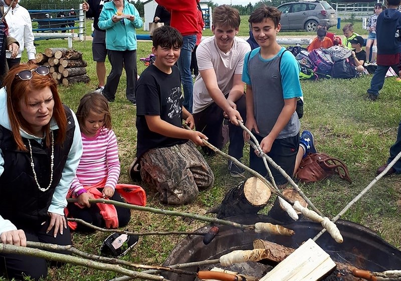 (L-R) Boyle School educational assistant Cary Marshall, and students Ivory Peppin, Joe Lachance, Scott Proctor and Chad Westlund cook hot dogs and bake bannock over the fire