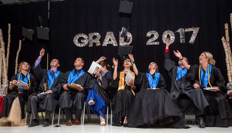 Annalise Walker, Tyson Tymo, Jaden Shulhan, Taylor Shapka, Laurel Johnson, Deanna Homeniuk, Jordan Heatherington and Victoria Baldwin throw their caps in their air after the