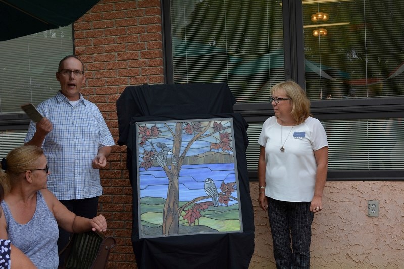 Thom Rypien and Joan Cody present the new stained glass mural at Extendicare&#8217;s 50th anniversary Sept. 9.